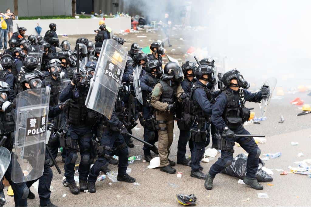 Riot police bunch up next to a cloud of tear gas during clashes with protesters