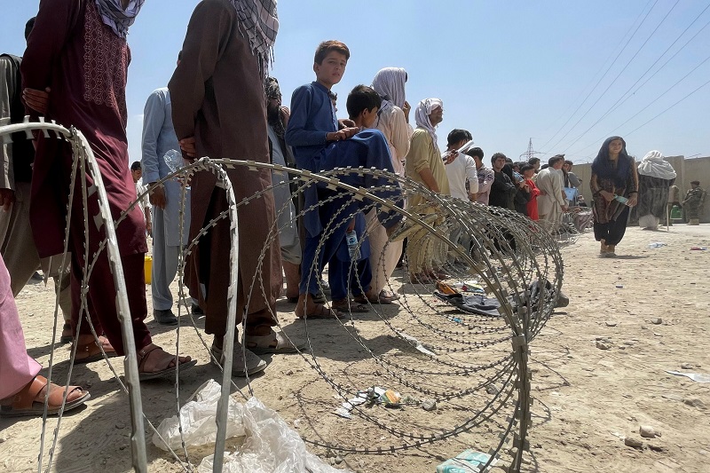 people wait outside hamid karzai international airport in kabul