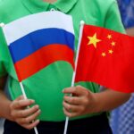 a child holds national flags of russia and china prior to a welcoming ceremony for russian president vladimir putin outside the great hall of the people in beijing