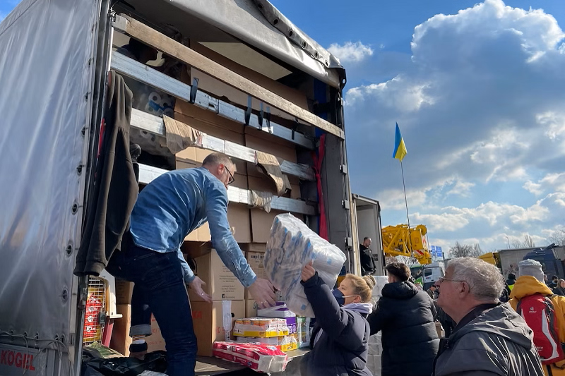  Local Ukrainians load up a container to carry supplies to the front lines